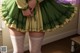 A woman in a green dress and white stockings.