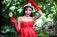 A woman in a red dress holding a lollipop.