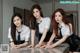 A group of three young women in school uniforms posing for a picture.