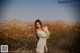 A woman in a white dress standing in a field.