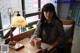 A woman sitting at a table with a cup of coffee.