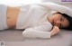 A woman laying on the floor with her hands on her head.