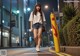 A woman walking down the street at night. 